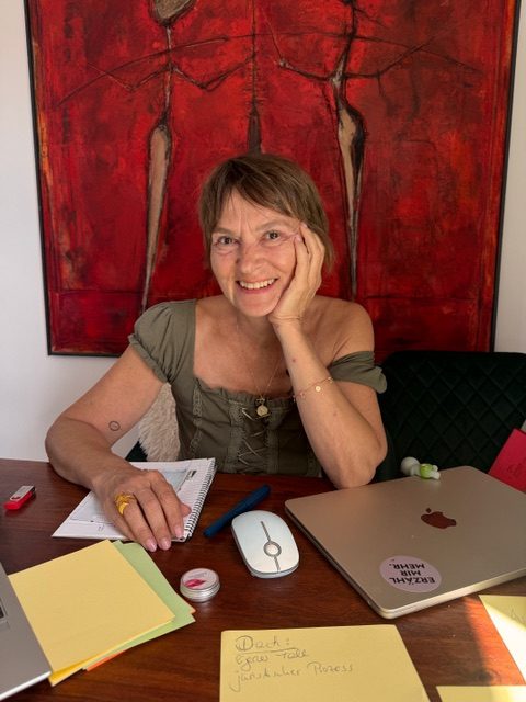 Claudia am Schreibtisch mit Notizblock und Laptop