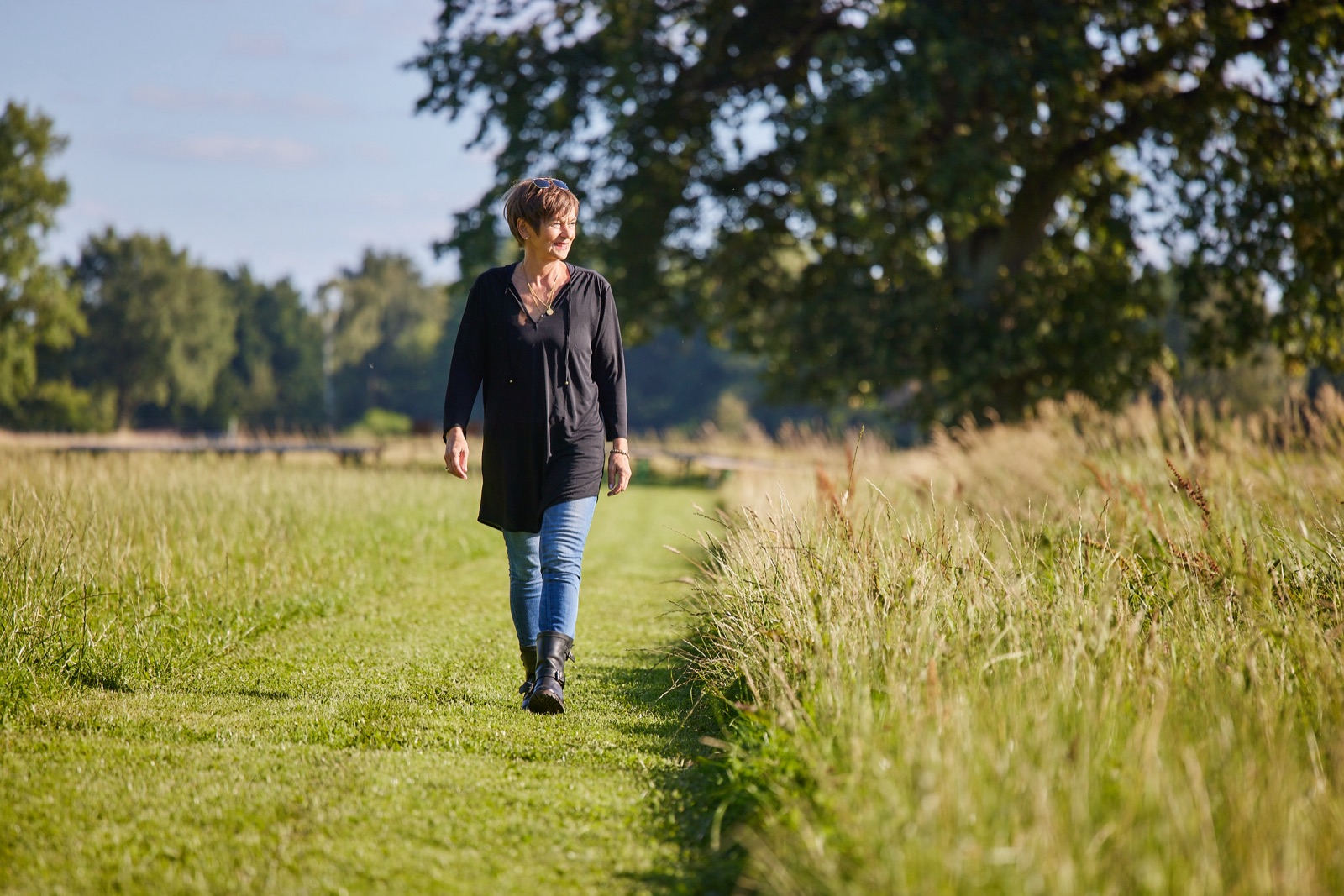 Claudia Wuttke geht über einen Feldweg, von Sonne beschienen